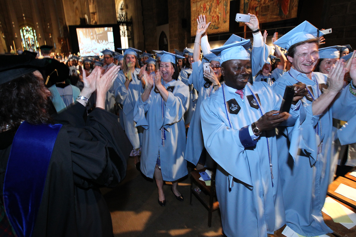 Students walk into Convocation in their caps and gowns